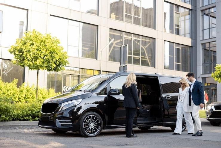Professional chauffeur service with clients beside a vehicle